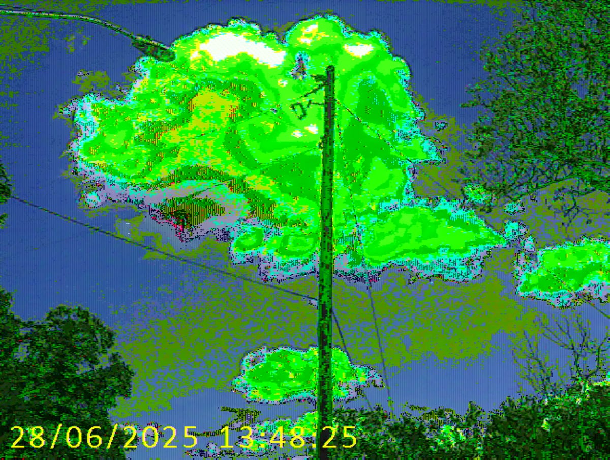 Green and blue neon image of a telephone pole, pixelated