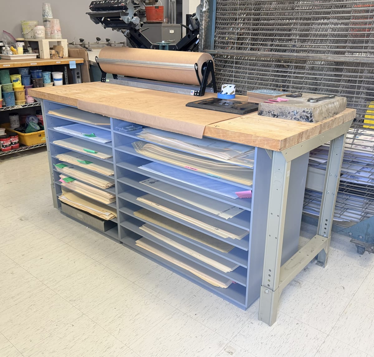 Blue-gray shelf storing paper in a print studio