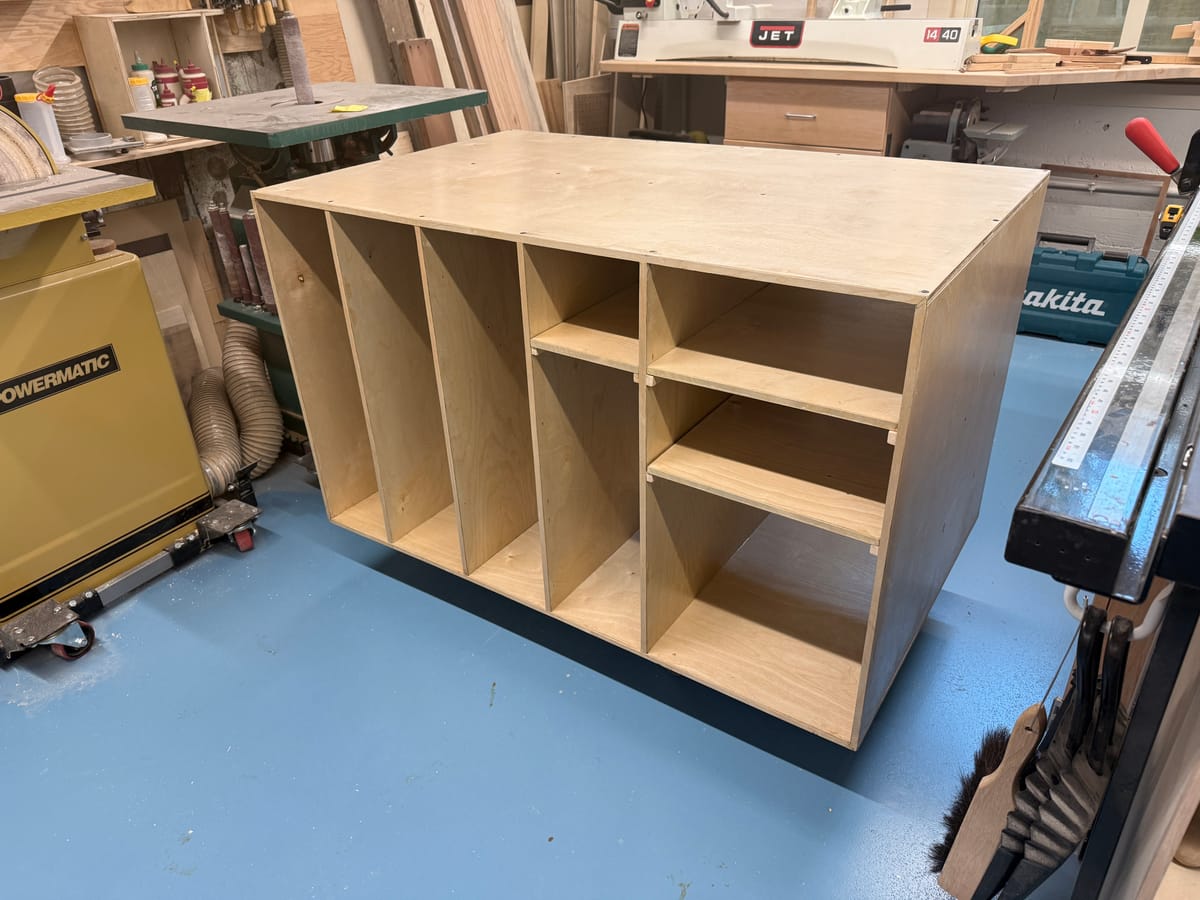 Wooden shelf for storing cardboard with a woodshop in the background