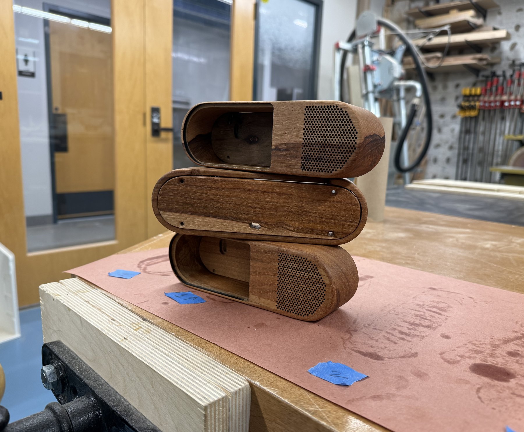 Three hand-shaped wooden DAWN housings stacked on the workbench