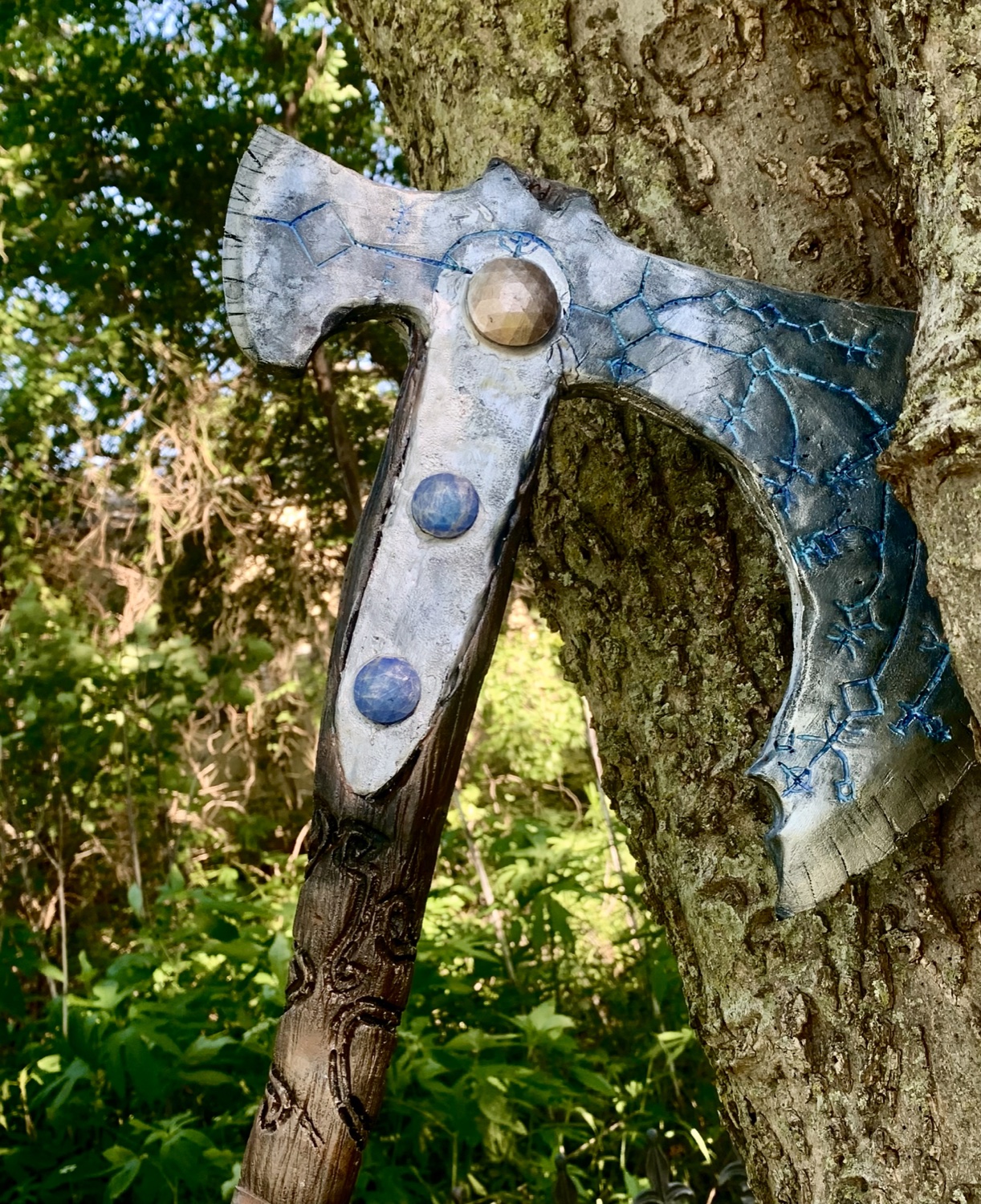 Hand-finished Leviathan axe replica against a tree